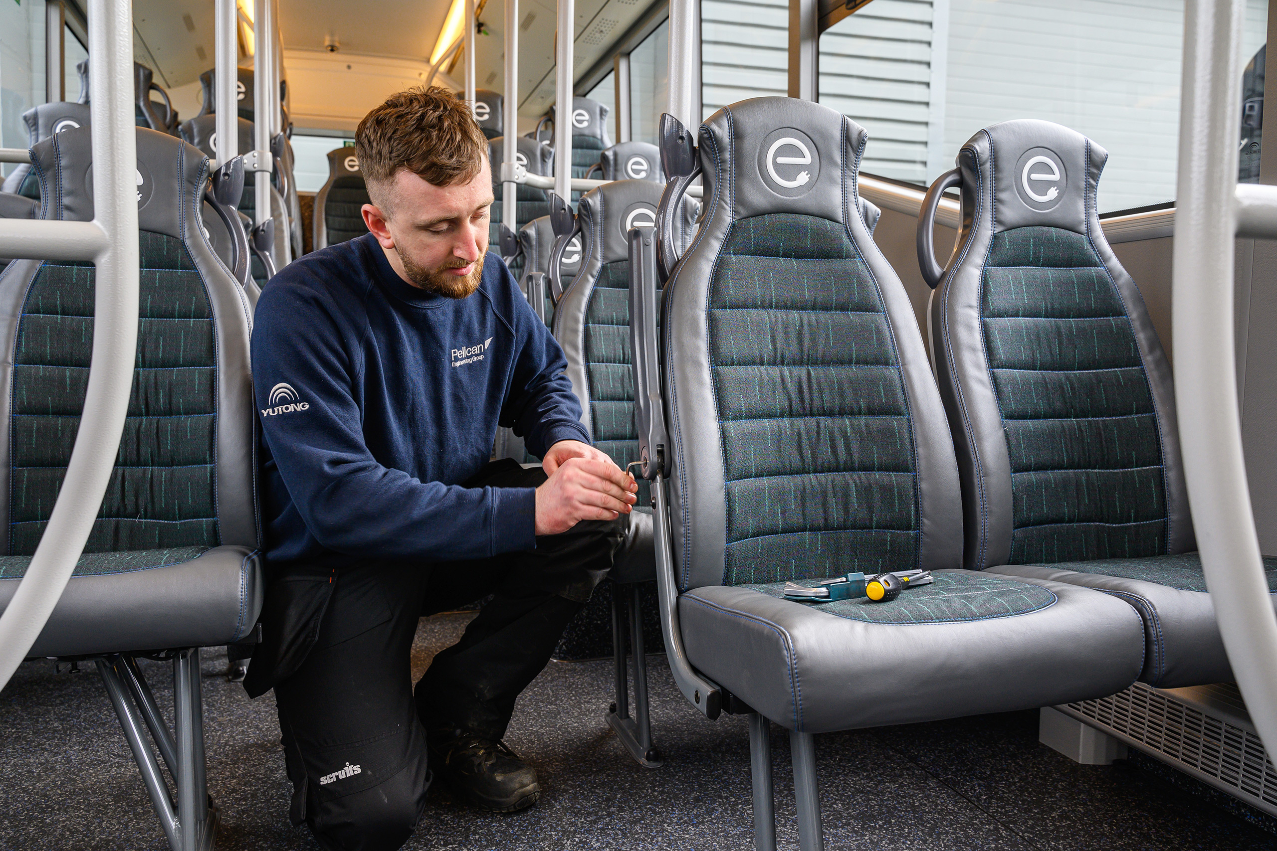 Completed in the UK - photo of a Pelican technician completing the installion of seats in an electric bus